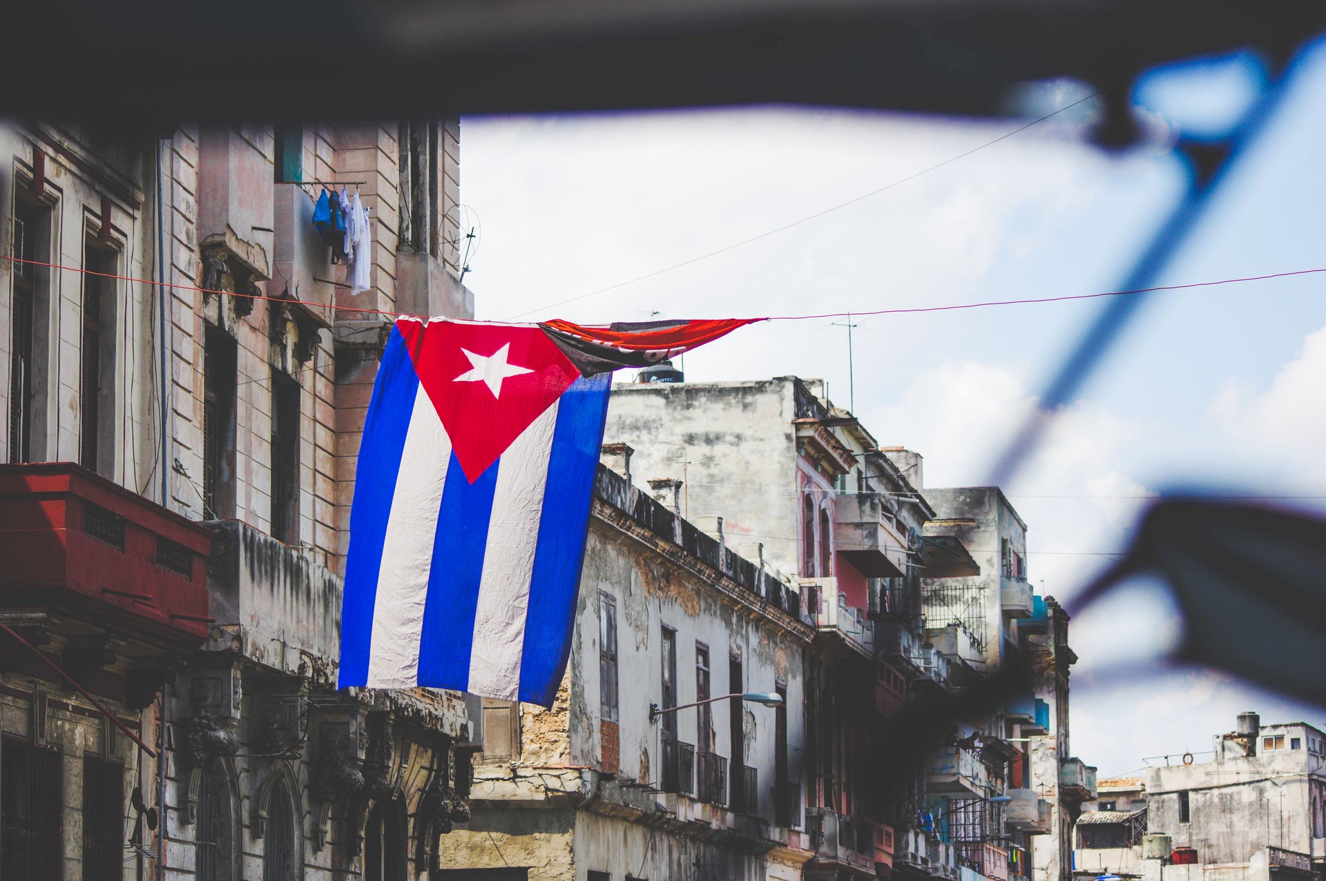 Everyday life in the street of Havana in Cuba with people going about their way in a colorful and vibrant organized chaos with a vintage and traditional vibe